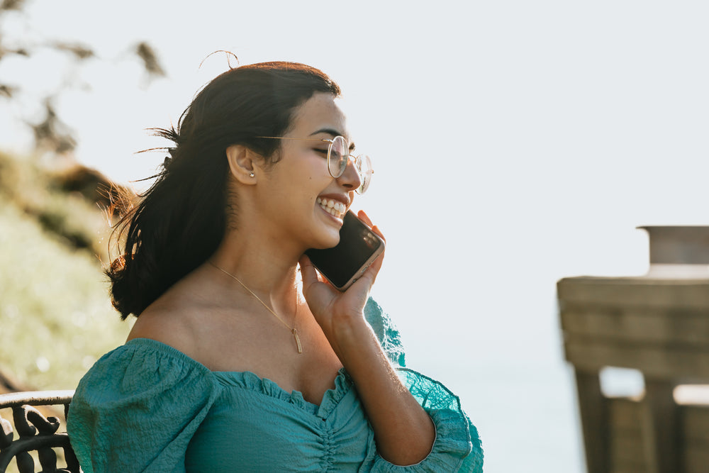 woman-smiles-and-holds-a-cellphone-to-her-ear